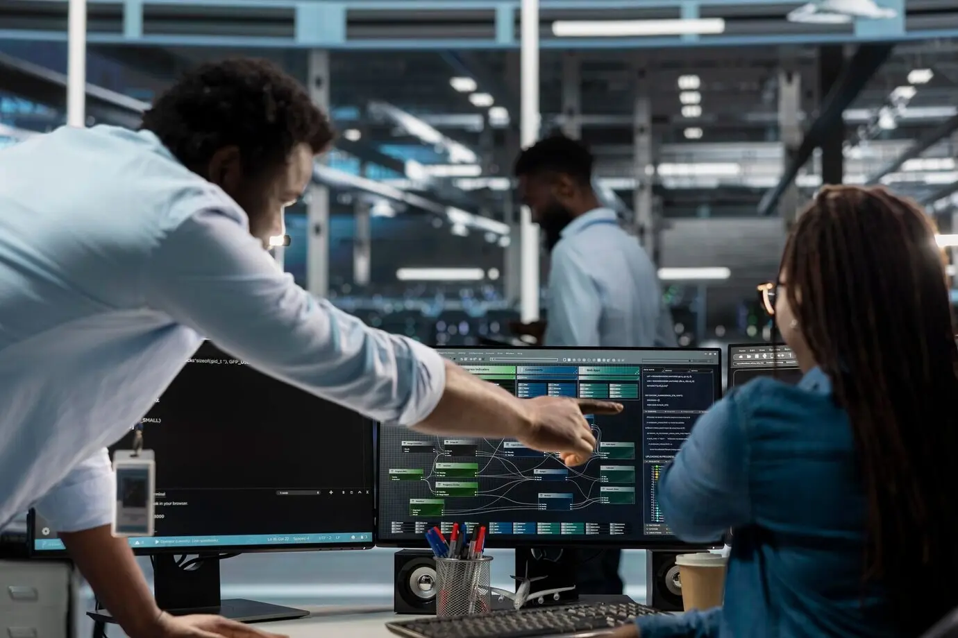 Supervisor de centro de datos supervisando a un administrador que usa una PC para visualizar árboles de nodos de IA.