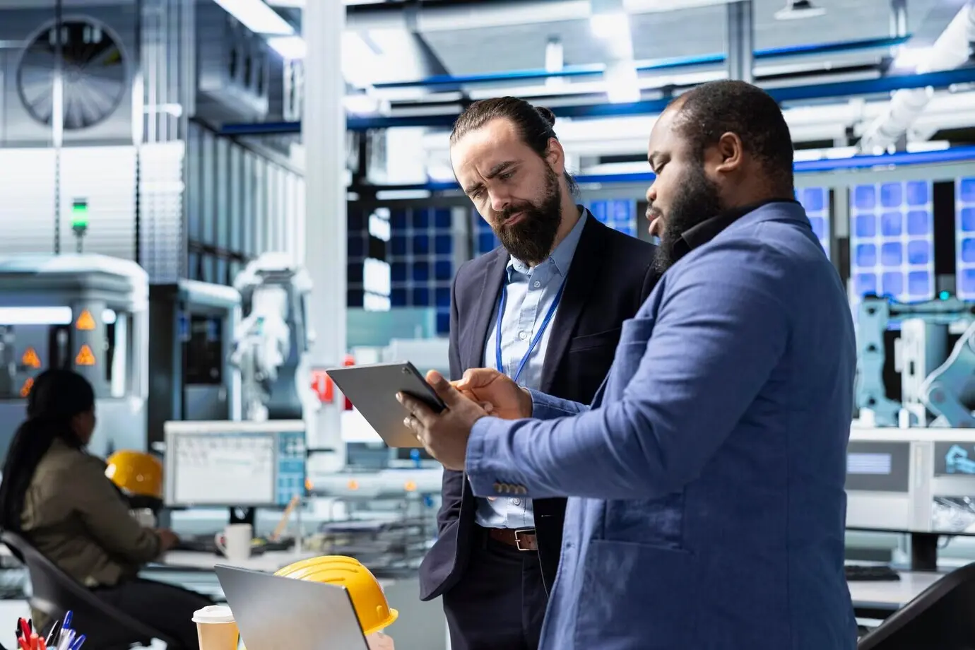 Ingenieros especialistas multiétnicos trabajando en equipo en una línea de producción moderna